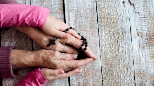 grand-mère et fillette qui prient le rosaire